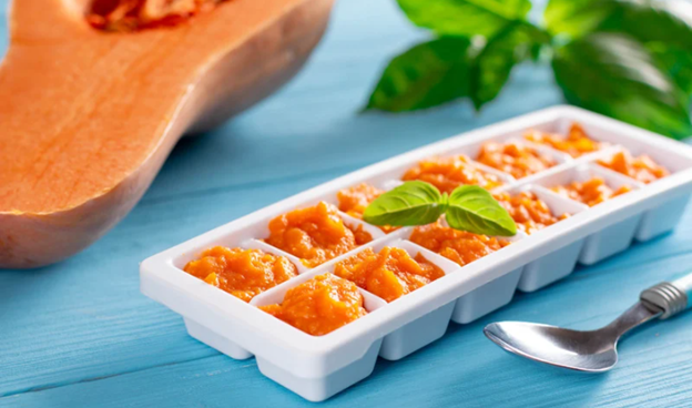 Homemade baby food. Reduce Waste. Eco-Friendly Baby Food. Sustainable Baby Feeding. Healthy Baby Food at Home. Homemade puree inside of an ice cube tray.