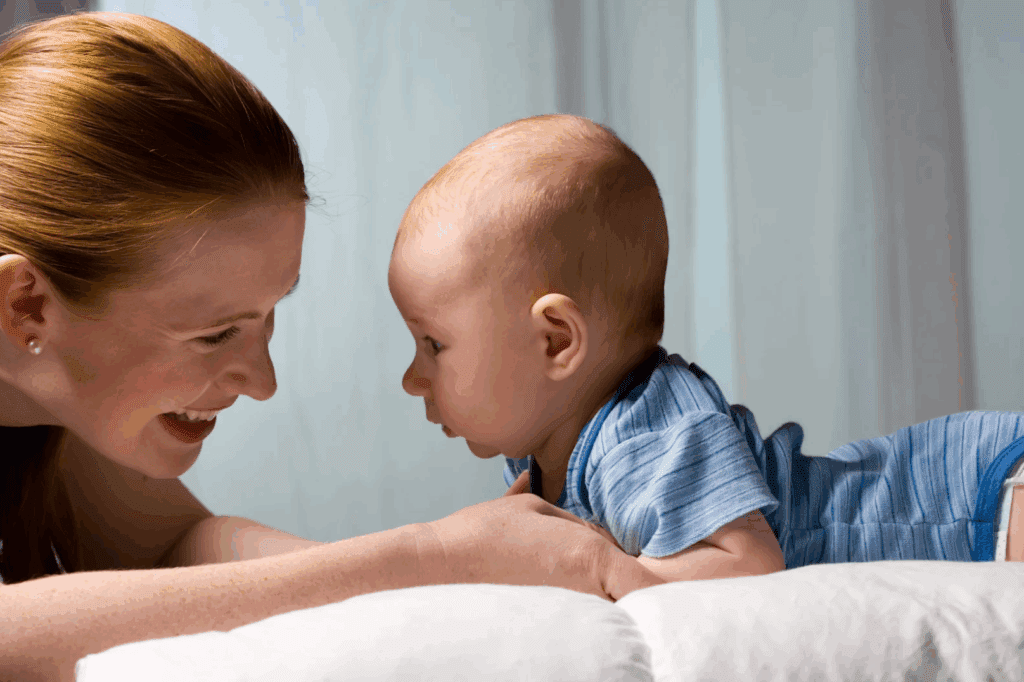 Mom looking a baby in the eyes, smiling. A mindful moment.